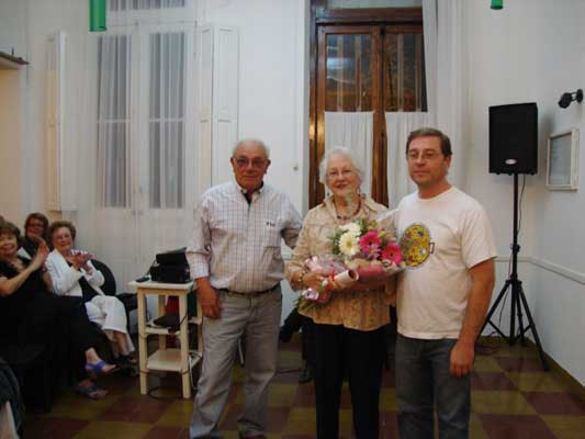 El presidente del Hiru Erreka, Mario Rodriguez Goizueta, y el secretario Silvio Laborde, entregaron el presente floral a Maria Teresa Urdampilleta (fotoEE)